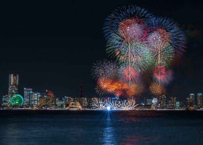 The Yokohama Sparkling Twilight fireworks festival. The sky explodes with multi-colored fireworks.